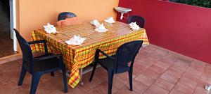 ein Tisch mit Stühlen und ein Tischtuch darauf in der Unterkunft Villa Punch Alizés 28, Route de la colline 97160 Le Moule in Le Moule