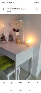 a white desk with a candle and a stuffed animal on it at Apartament două camere in Uricani