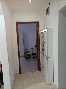 a kitchen with a door open to a kitchen with a refrigerator at Apartament două camere in Uricani