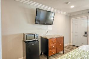 a room with a tv on the wall and a bed at ERTH INN by AGA- Mojave in Mojave +32 photos