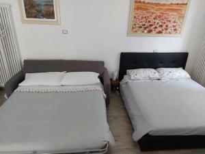 dwa łóżka siedzące obok siebie w pokoju w obiekcie Iris home w mieście Camblione