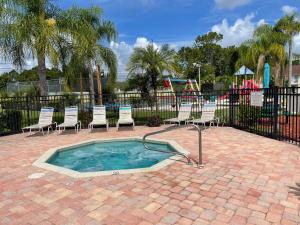 a small swimming pool with chairs and a playground at LOVELY RENOVATED APARTMENT 3/2 CLOSE DISNEY in Kissimmee