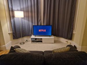 a living room with a couch and a tv at Lovely One Bed Apartment in Guildford in Guildford