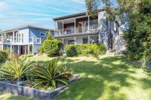 an exterior view of a house with a yard at Baggies On Dutchies, 9 Burbong Street - Large Pet Friendly house with spectacular waterviews, Wi-Fi and air con in Nelson Bay