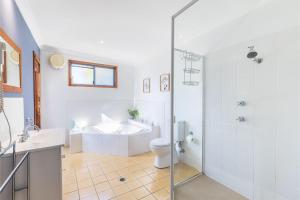 une salle de bain avec une baignoire, des toilettes et un lavabo dans l'établissement Baggies On Dutchies, 9 Burbong Street - Large pet friendly house with spectacular waterviews, Wi-Fi and air con, à Nelson Bay 25 autres photos