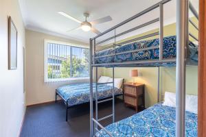 a bedroom with two bunk beds and a window at Baggies On Dutchies, 9 Burbong Street - Large Pet Friendly house with spectacular waterviews, Wi-Fi and air con in Nelson Bay