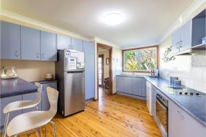 a kitchen with blue cabinets and a counter top at Baggies On Dutchies, 9 Burbong Street - Large Pet Friendly house with spectacular waterviews, Wi-Fi and air con in Nelson Bay