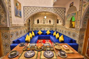 a blue couch in a room with a table at Riad Moroccan Style in Fez