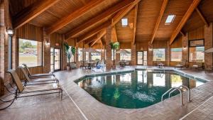 a large swimming pool in a building with tables and chairs at Best Western Jacksonville Inn in Jacksonville