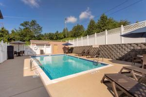 a swimming pool with tables and chairs next to a building at Best Western Lawrenceburg Inn in Lawrenceburg