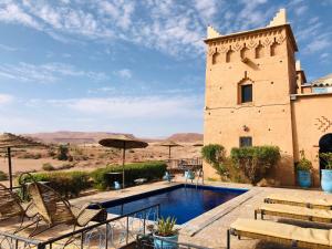 un patio avec une piscine et des chaises et un bâtiment dans l'établissement Kasbah Rayane Ait Ben Haddou, à Aït Ben Haddou