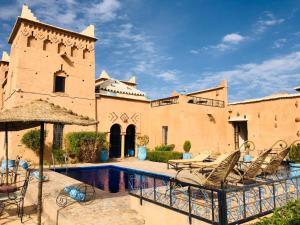 a courtyard with chairs and a swimming pool in a building at Kasbah Rayane Ait Ben Haddou in Aït Benhaddou