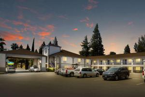 Un gran edificio con coches aparcados en un estacionamiento. en SureStay Hotel by Best Western Ukiah, en Ukiah