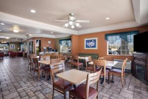 a restaurant with tables and chairs and a bar at SureStay Hotel by Best Western Ukiah in Ukiah