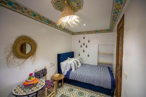 1 dormitorio con cama, espejo y mesa en Riad Moroccan Style, en Fez