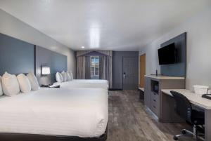 a hotel room with a bed and a desk and a television at SureStay Hotel by Best Western Ukiah in Ukiah