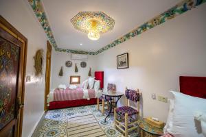 1 dormitorio con 1 cama, mesa y sillas en Riad Moroccan Style, en Fez