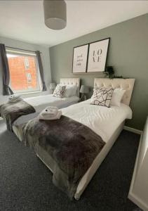 a bedroom with two beds and a window at Hamble Lounge - Accomodation for Aylesbury Contractors & Industrial estate - Free Parking & WIFI Sleeps up to 6 people in Buckinghamshire