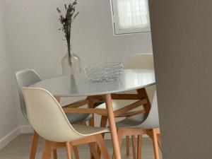 a white table with chairs and a vase of flowers at Torreira Vacation Homes - Sea House in Torreira +25 photos