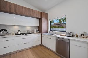 a kitchen with white cabinets and a window at Villa Paradise Miami, Luxury Gem with Heated Pool, Game Room, Fire Pit, 3 Bed 2 Bath in Miami