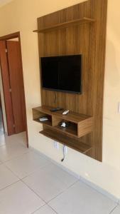 a flat screen tv on a wall in a room at Vila do Rosa in Praia do Rosa