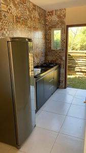 a kitchen with a stainless steel refrigerator in it at Vila do Rosa in Praia do Rosa