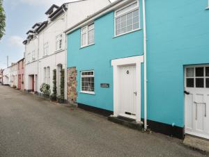 uma fila de casas pintadas com cores vivas numa rua em The Old Coach House em Beaumaris