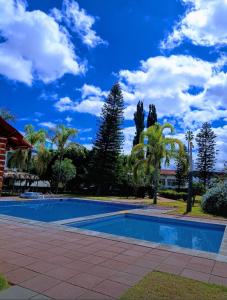 einen Pool in einem Garten mit blauem Himmel in der Unterkunft HOTEL SAN MARCOS in Aguascalientes