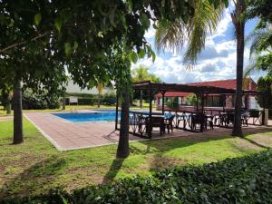 una zona de picnic con mesas y un pabellón junto a una piscina en HOTEL SAN MARCOS, en Aguascalientes