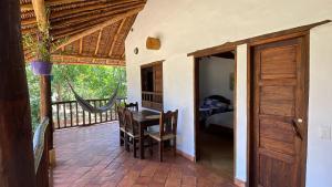 a room with a balcony with a table and a bed at cabañas villa Angelica in Barichara
