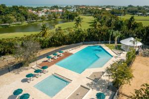 an overhead view of a swimming pool with chairs and umbrellas at 1BR Apt at Green One in Muñoz