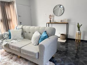 ein Wohnzimmer mit einem Sofa und einem Spiegel in der Unterkunft Hermosa casa estilo nórdico en tranquilo barrio céntrico in Mendoza
