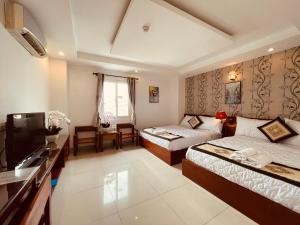 een hotelkamer met 2 bedden en een televisie bij SaiGon Europe Hotel in Ho Chi Minh-stad