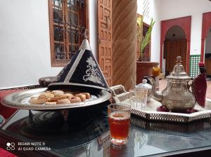 een schaal koekjes op tafel met een drankje bij Riad Dar Badiaa in Sale +54 foto's
