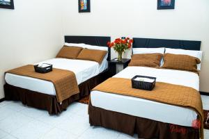 two beds sitting next to each other in a room at Hotel Paris in Machala