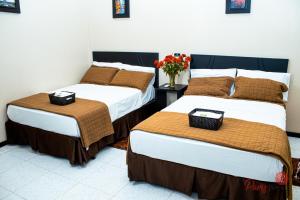 zwei Betten nebeneinander in einem Zimmer in der Unterkunft Hotel Paris in Machala