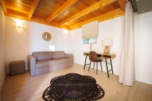ein Wohnzimmer mit einem Sofa und einem Tisch in der Unterkunft Vila Marim Country Houses in Mesão Frio
