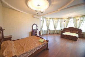 a bedroom with two beds and a clock and windows at Luxury Villa in Odesa