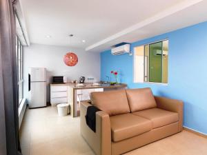 a living room with a couch and a kitchen at Fenix Inn in Malacca