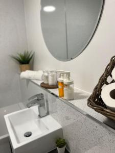 a white bathroom with a sink and a mirror at Stunning 2-Bed Apart in the heart of Aberdeen* in Aberdeen