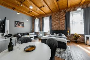 a bedroom with a bed and a living room at Vintage Industrial City Apartments in Košice