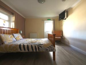 ローアーンにあるDylan's Courtのベッドルーム1室(ベッド1台、壁掛けテレビ付)