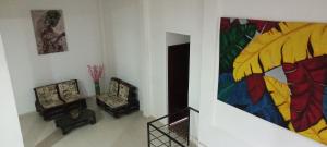 a living room with two chairs and a painting on the wall at MANIPURA in Guaduas