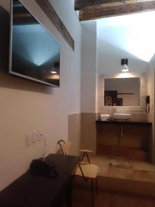 een badkamer met een tafel, een wastafel en een spiegel bij Hotel Sonno Plaza Allende in Mexico-Stad