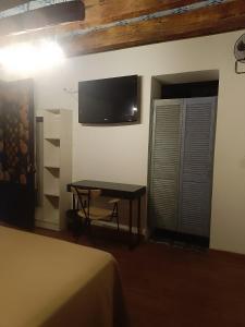 Habitación con mesa y TV en la pared. en Hotel Sonno Plaza Allende, en Ciudad de México