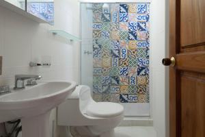 een badkamer met een wastafel, een toilet en een douche bij La Casita Azul Cozy Colonial House at Centro Historico with Rooftop and Jacuzzi in Cartagena