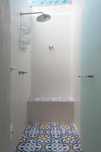 een badkamer met een douche en een tegelvloer bij La Casita Azul Cozy Colonial House at Centro Historico with Rooftop and Jacuzzi in Cartagena