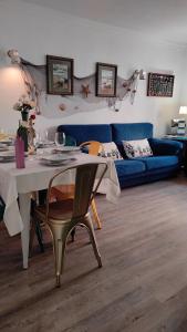 sala de estar con mesa y sofá azul en Casa Marenga El Palo, en Málaga