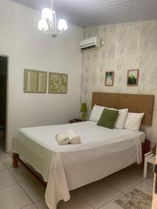 um quarto com uma grande cama branca com toalhas em Vila Vitória Pousada em Pirenópolis
