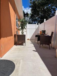 a patio with two benches and a table and a fence at The Citrus Guesthouse in Tampa in Tampa